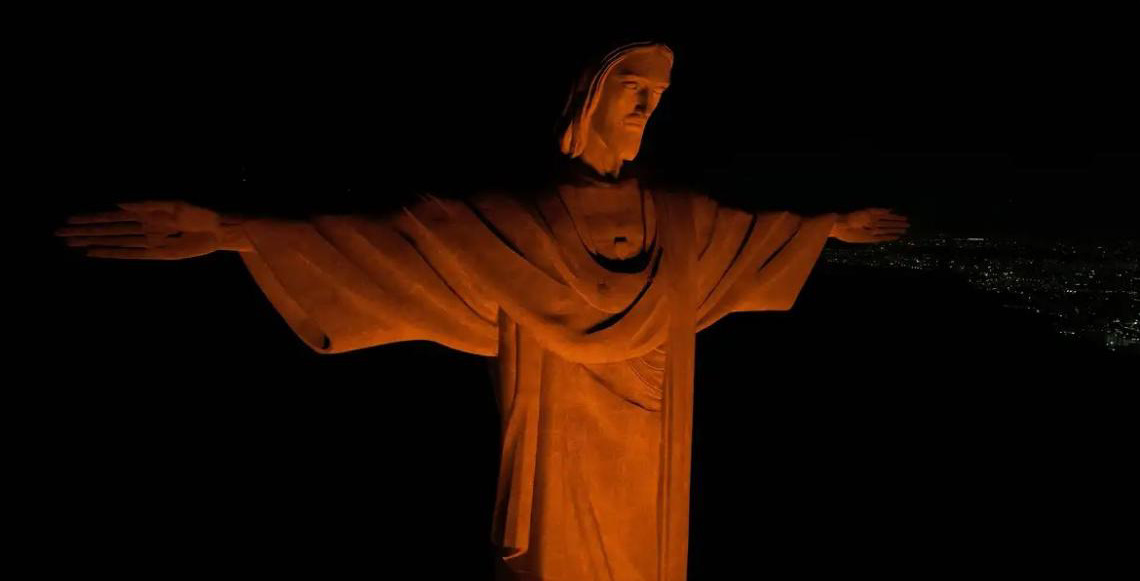 Cristo Redentor, no Rio de Janeiro, está iluminado na cor laranja em alerta contra o feminicídio