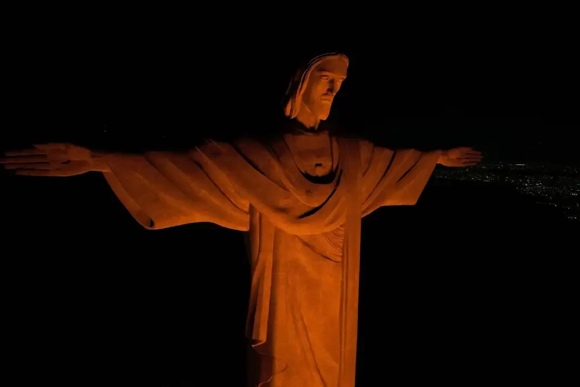 Cristo Redentor, no Rio de Janeiro, está iluminado na cor laranja em alerta contra o feminicídio